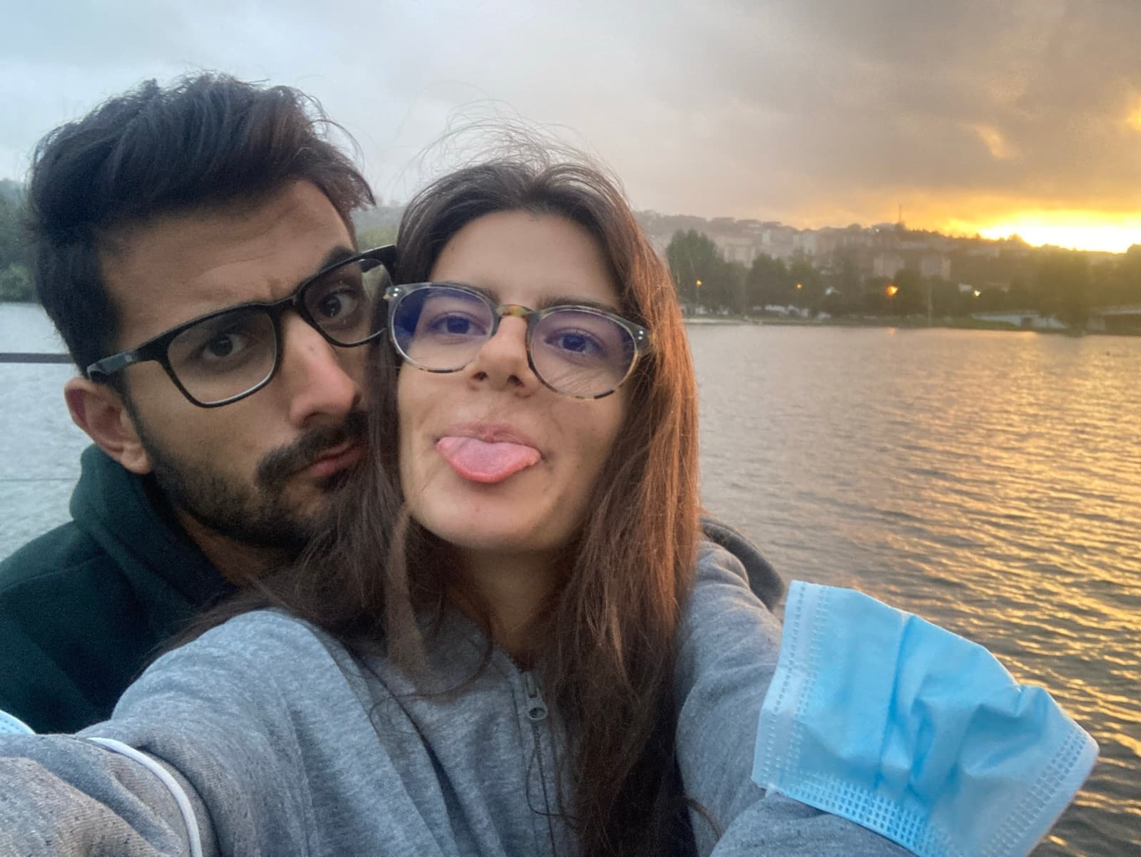 Sofia e Rodrigo à beira do rio ao pôr do sol, a fazer caretas